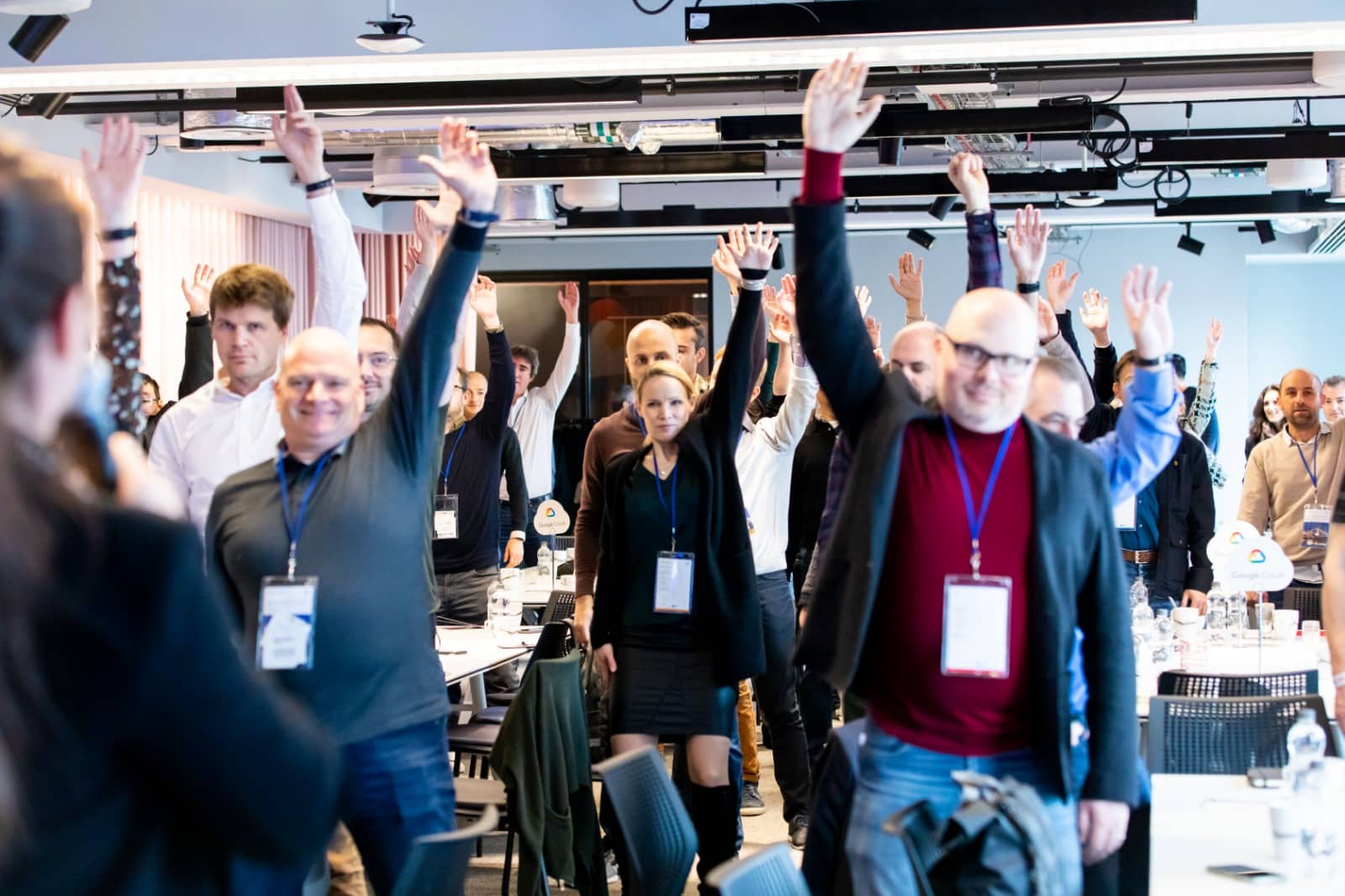 Diverse group of professionals engaged in authentic dialogue around a round table in a co-working space, symbolizing experiential learning, adaptive leadership, and collective intelligence in a real-world environment.